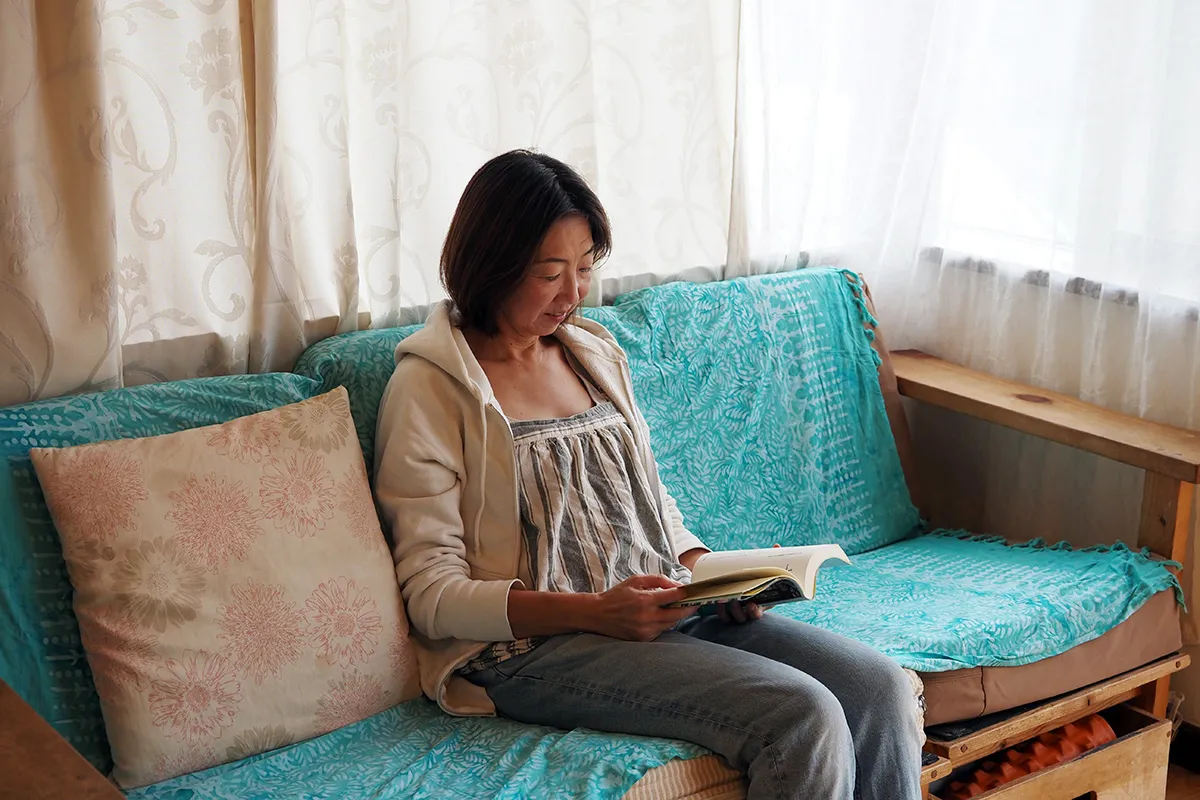 【ご主人がDIYしたソファーで読書をする川上さん】