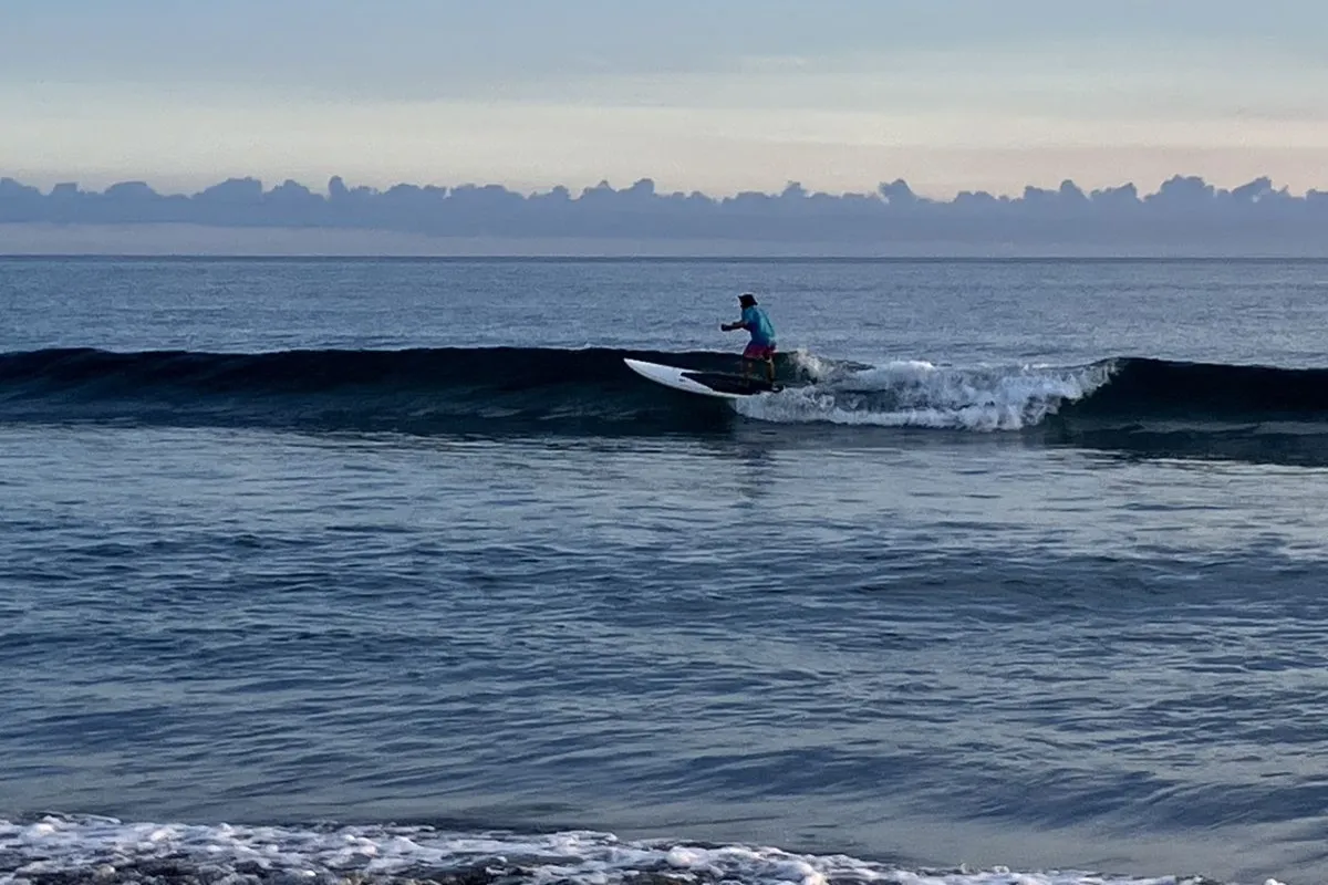 【サーフィンをする富山さん】