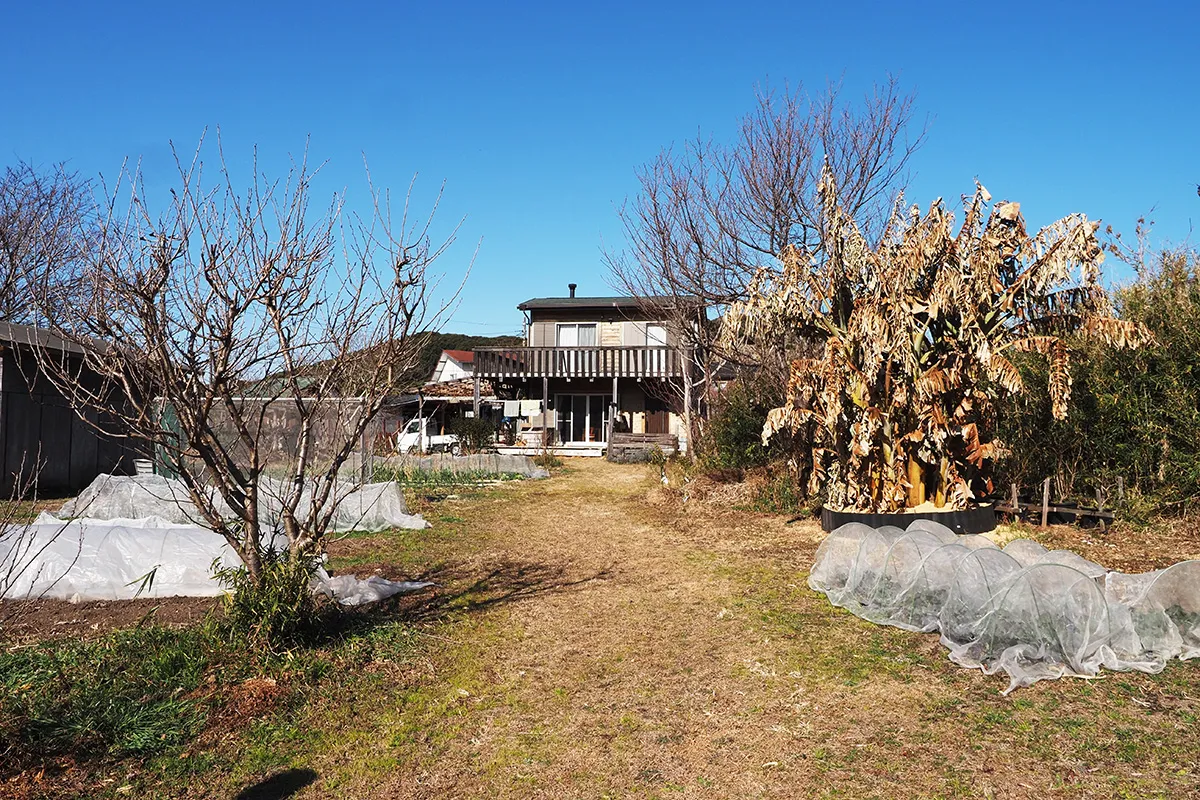 【畑から眺めた家の正面。1階にも2階にもL字のテラスがある】