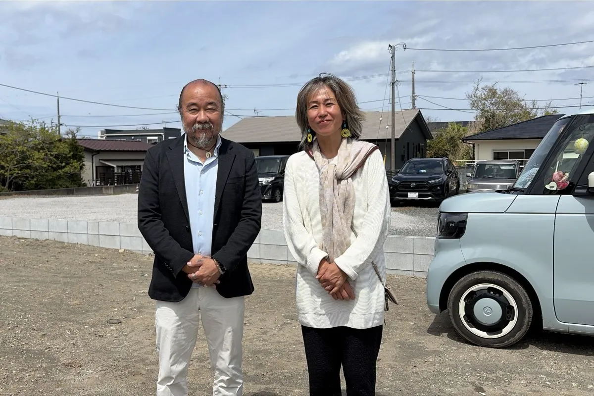 【これから家が建つ土地で微笑む大和田さんご夫妻】