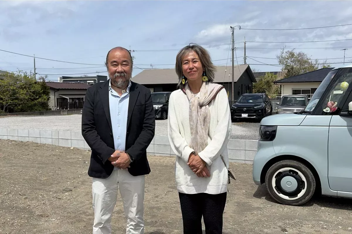 【これから家が建つ土地で微笑む大和田さんご夫妻】
