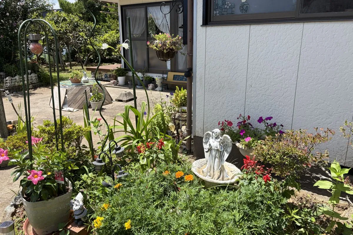 【花や小物が配された庭。井戸にも装飾が施され、日々の暮らしを楽しむ工夫が感じられます】