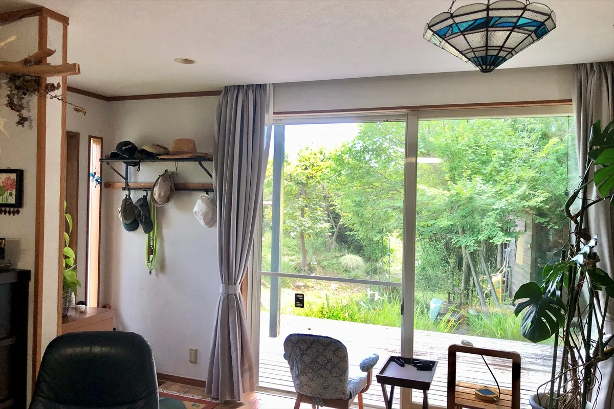 【リビングと窓の外のウッドデッキ。庭の小屋は伸男さんのDIY】